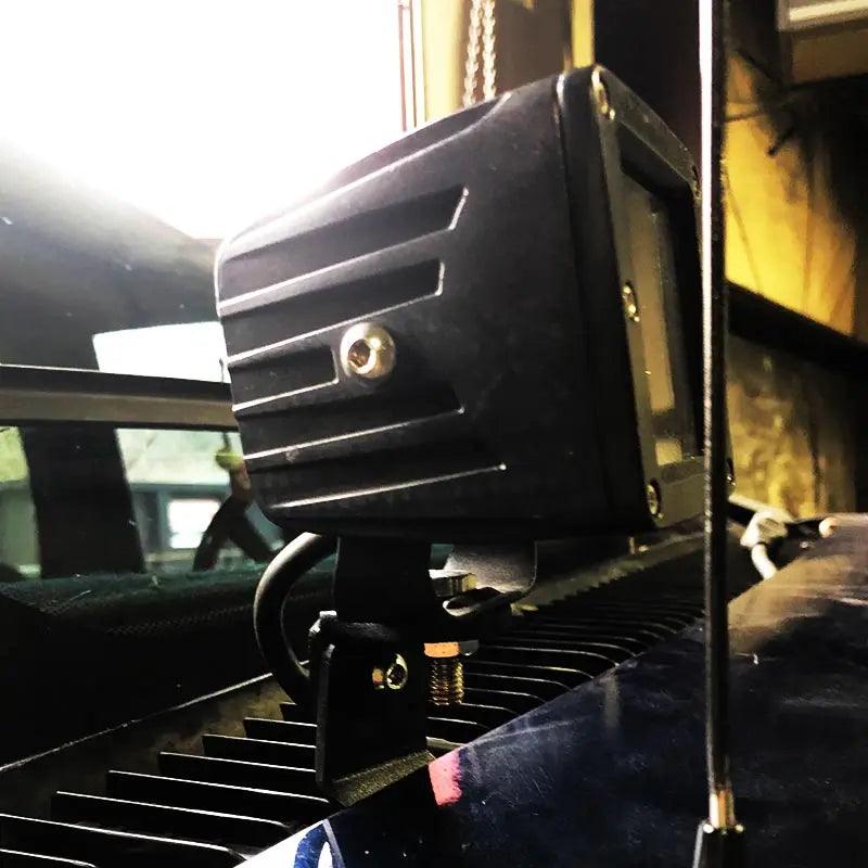 1989-1999 GMC Yukon Hood Ditch Light Mounts black powder coat steel brackets installed on vehicle hood hinges